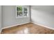Bright bedroom featuring a large window, hardwood floors, and neutral paint at 3312 Apache Dr, Raleigh, NC 27609