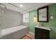 Cozy bathroom with mosaic tile accents, tub with shower, vanity with marble counter, and a green painted wall at 3420 Sheridan Dr, Durham, NC 27707