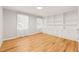 Bright bedroom featuring hardwood floors, built-in shelving, and natural light from two windows at 3420 Sheridan Dr, Durham, NC 27707