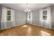 Charming dining room featuring hardwood floors, a chandelier, neutral paint, and large windows with natural light at 3420 Sheridan Dr, Durham, NC 27707