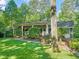 Brick home with a well-maintained lawn, mature trees, shrubs, and a front porch with columns at 3420 Sheridan Dr, Durham, NC 27707