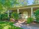 Inviting brick home featuring manicured landscaping, a brick walkway, and a covered front porch with columns at 3420 Sheridan Dr, Durham, NC 27707