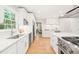 Modern kitchen featuring white cabinets, stainless steel appliances, and hardwood flooring at 3420 Sheridan Dr, Durham, NC 27707