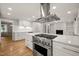 Modern kitchen with stainless steel appliances, white cabinets, large island, and hardwood floors at 3420 Sheridan Dr, Durham, NC 27707