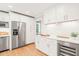 Elegant white kitchen with wine storage, stainless steel appliances, and hardwood floors at 3420 Sheridan Dr, Durham, NC 27707