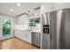 Bright kitchen features white cabinets, stainless appliances, and a window over the sink with a view to the outdoors at 3420 Sheridan Dr, Durham, NC 27707