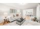 Bright living room with neutral decor featuring a stylish sofa, art and hardwood floors at 3420 Sheridan Dr, Durham, NC 27707