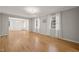 Bright living room features hardwood floors, neutral paint, large windows with white curtains, and decorative crown molding at 3420 Sheridan Dr, Durham, NC 27707