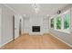 Open living room featuring fireplace, large windows, and views of surrounding greenery at 3420 Sheridan Dr, Durham, NC 27707
