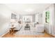Bright living room with hardwood floors and white furniture flows into the dining area at 3420 Sheridan Dr, Durham, NC 27707