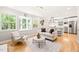 Open-concept living room with hardwood floors, large windows, and a view into the kitchen at 3420 Sheridan Dr, Durham, NC 27707