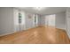 Well-lit living room with hardwood flooring, light gray walls, white trim, and windows dressed with sheer curtains at 3420 Sheridan Dr, Durham, NC 27707