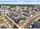 An aerial view showcasing modern townhomes with manicured lawns in a well-planned community and beautiful blue sky at 353 Rivella Dr, Wake Forest, NC 27587