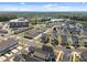 An aerial view capturing the serene lake near modern townhomes with well-maintained lawns and landscaping under a blue sky at 353 Rivella Dr, Wake Forest, NC 27587