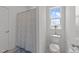 Bright bathroom featuring a shower with decorative curtain and a window at 353 Rivella Dr, Wake Forest, NC 27587