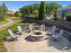 Stone fire pit with Adirondack chairs in a landscaped community space, perfect for outdoor gatherings at 353 Rivella Dr, Wake Forest, NC 27587