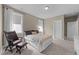 Calm main bedroom with a queen bed, chair and ottoman, and soft natural light at 353 Rivella Dr, Wake Forest, NC 27587