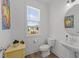 Cozy powder room with modern fixtures, decorative artwork and a view to the backyard at 353 Rivella Dr, Wake Forest, NC 27587