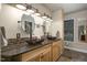 Bathroom featuring dual sinks, granite counters, custom mirrors, and modern lighting fixtures at 3636-A Holly Grove Rd, Dunn, NC 28334