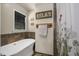 Bright bathroom featuring a freestanding tub, tile accent wall, and natural light at 3636-A Holly Grove Rd, Dunn, NC 28334