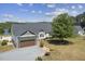 Charming home exterior with a large garage, mature trees, and well-maintained landscaping at 3636-A Holly Grove Rd, Dunn, NC 28334