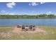 Lakeside lounge area with chairs, a fire pit, and a scenic view, creating a perfect spot for relaxation and outdoor enjoyment at 3636-A Holly Grove Rd, Dunn, NC 28334