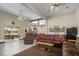 Spacious living room featuring a leather sofa, ceiling fans, and access to an outdoor seating area with lake views at 3636-A Holly Grove Rd, Dunn, NC 28334