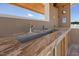 Close-up of an outdoor bar featuring a granite countertop, sink, and backsplash, perfect for entertaining by the pool at 3636-A Holly Grove Rd, Dunn, NC 28334
