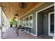 Relax on the porch with views, stained wood ceilings, and outdoor lighting at 3636-A Holly Grove Rd, Dunn, NC 28334