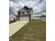 New home featuring a two-car garage, stone accents, and a spacious lawn ready for landscaping at 364 Peach Grove Way, Lillington, NC 27546