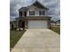 Two-story home with stone accents, a two-car garage, and a well-manicured front lawn at 364 Peach Grove Way, Lillington, NC 27546