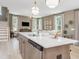 Open-concept kitchen features a center island, stainless steel dishwasher, and view into the adjacent living room at 364 Peach Grove Way, Lillington, NC 27546