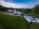 Expansive backyard showcasing a modern pool, lush lawn, and elegant home with a scenic view of the lake at 4001 Campbell Rd, Raleigh, NC 27606