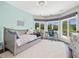 Well lit bedroom with a large window, light blue accent wall, and a desk at 4001 Campbell Rd, Raleigh, NC 27606
