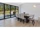 Modern dining room with a view of the backyard, featuring a long wooden table with seating for eight at 4001 Campbell Rd, Raleigh, NC 27606