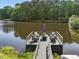 Cozy seating area on a dock with a view of the tranquil pond and surrounding nature at 4001 Campbell Rd, Raleigh, NC 27606