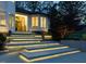 Exterior front entrance with illuminated steps, beautiful stone facade, and wood door at 4001 Campbell Rd, Raleigh, NC 27606