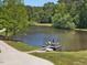 Scenic view of the lake featuring a cozy dock with outdoor seating and a peaceful, natural setting at 4001 Campbell Rd, Raleigh, NC 27606