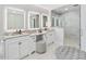 Beautiful main bathroom with double vanity, unique mirror design and walk-in shower with glass doors at 4001 Campbell Rd, Raleigh, NC 27606