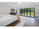 Bright main bedroom boasting hardwood floors and black framed sliding doors to an open private yard at 4001 Campbell Rd, Raleigh, NC 27606