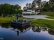 Picturesque view of the pond with a dock, outdoor seating, and reflection of the stately home at 4001 Campbell Rd, Raleigh, NC 27606