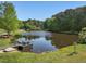 Beautiful pond with dock and seating area, surrounded by lush trees at 4001 Campbell Rd, Raleigh, NC 27606