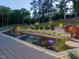 Beautifully landscaped pond with a deck, water feature, and lush plantings at 4001 Campbell Rd, Raleigh, NC 27606