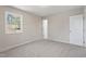 Cozy bedroom featuring neutral carpet, a large window with natural light and a door to the hallway at 4204 Green Rd, Raleigh, NC 27604