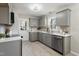 Modern kitchen with gray cabinets, stainless steel appliances, white countertops, and hardwood floors at 4204 Green Rd, Raleigh, NC 27604
