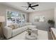 Bright living room features a large window, sectional sofa, ceiling fan, and neutral decor at 4204 Green Rd, Raleigh, NC 27604