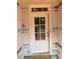 A new, white six-paneled entry door with transom window in an unfinished home construction setting at 436 Golden Dragonfly St, Wake Forest, NC 27587