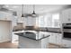 Bright kitchen features white cabinetry, stainless appliances, an island with seating and black countertops at 436 Golden Dragonfly St, Wake Forest, NC 27587