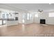 Open-concept living room and kitchen featuring wood floors, a fireplace, and plenty of natural light at 436 Golden Dragonfly St, Wake Forest, NC 27587