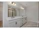Bright bathroom featuring a double sink vanity, a large mirror and a tiled glass-door shower at 440 Golden Dragonfly St, Wake Forest, NC 27587